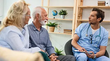 Doctor discussing care options with elderly couple during primary care visit