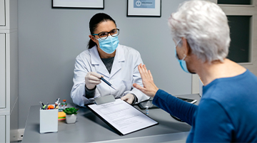 Doctor consulting elderly patient during preventive care visit