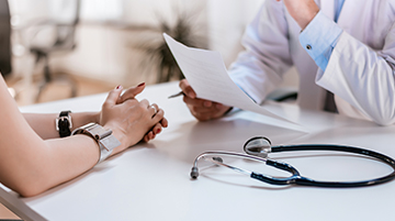 Doctor reviewing medical report with patient during consultation