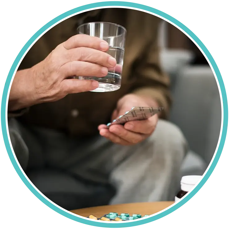 Patient holding medication and a glass of water at home