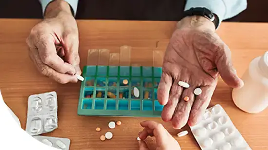 Patient organizing daily medications with pill box